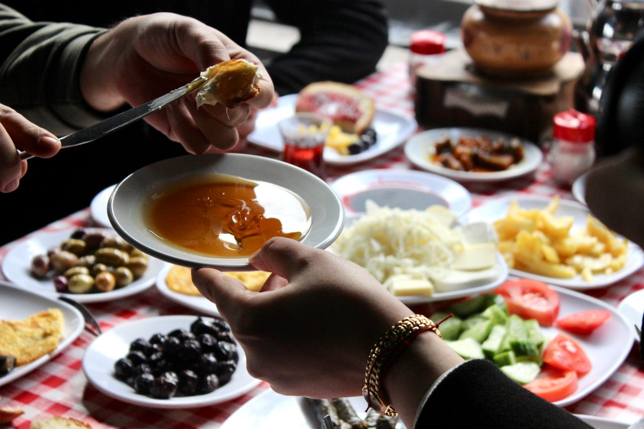 Çeşitli peynirler, zeytinler, domates, yumurta, simit ve çaydan oluşan geleneksel Türk kahvaltısı sofrası